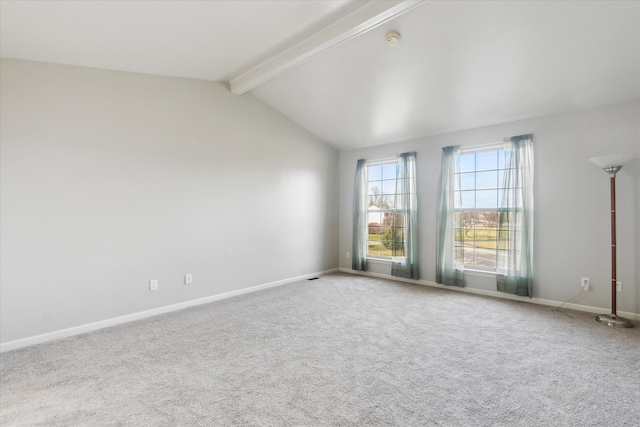 empty room with carpet and vaulted ceiling with beams