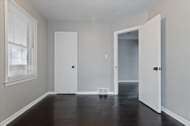 spare room with dark wood-type flooring