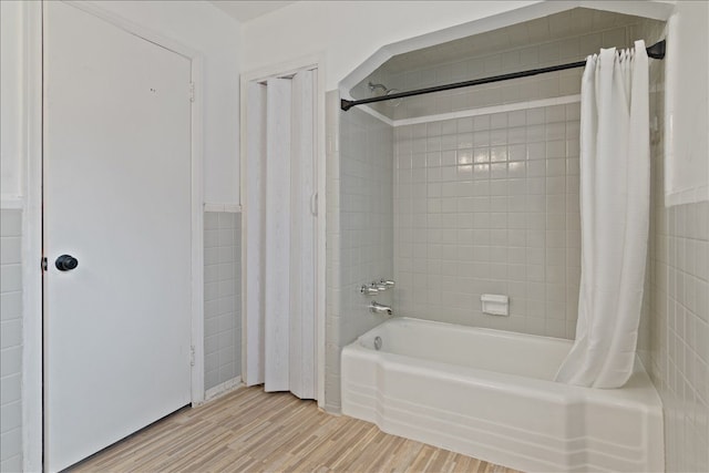 bathroom with hardwood / wood-style floors and shower / bath combination with curtain