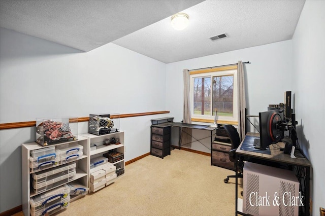 home office featuring light colored carpet and a textured ceiling