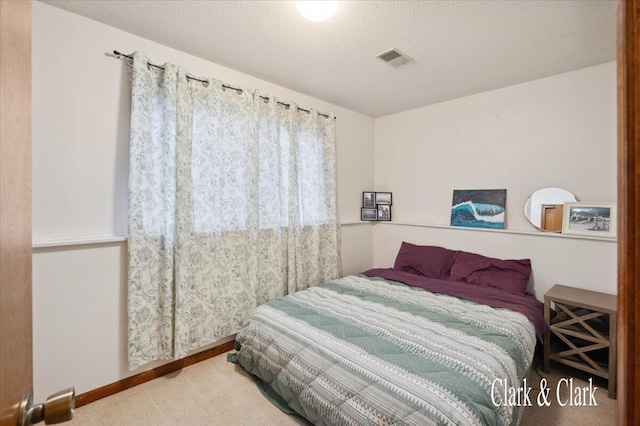 bedroom with carpet floors and a textured ceiling