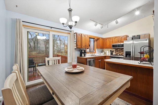 dining room featuring hardwood / wood-style floors, a chandelier, lofted ceiling, and sink