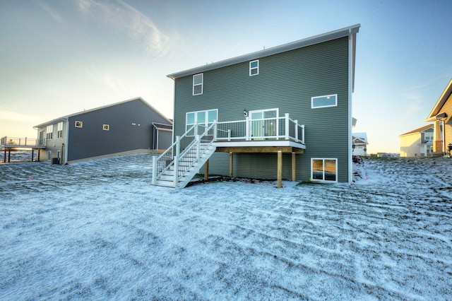 snow covered rear of property featuring a deck