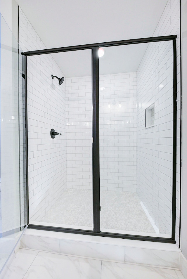 bathroom featuring a shower with shower door