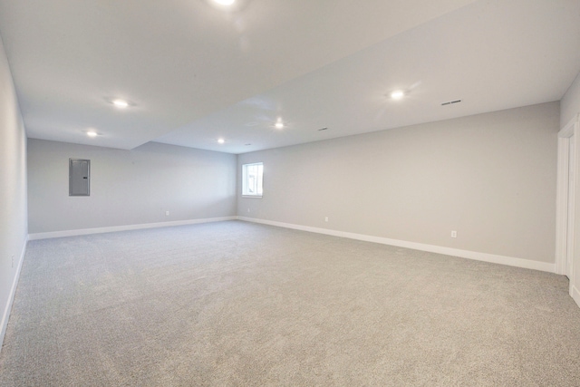 spare room featuring electric panel and light colored carpet