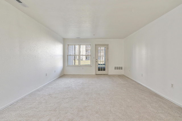 unfurnished room with light carpet