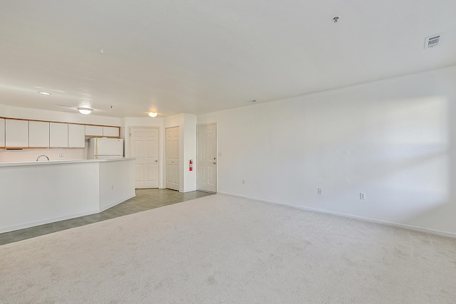 unfurnished living room featuring carpet