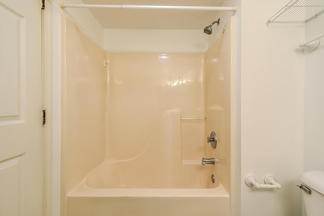 bathroom featuring shower / tub combination and toilet