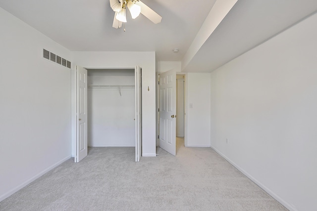 unfurnished bedroom with ceiling fan, a closet, and light colored carpet