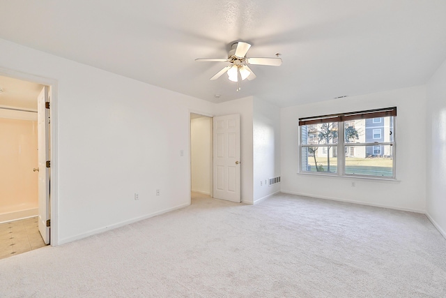 carpeted spare room with ceiling fan