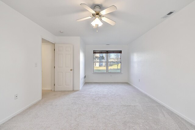 empty room with ceiling fan and light carpet