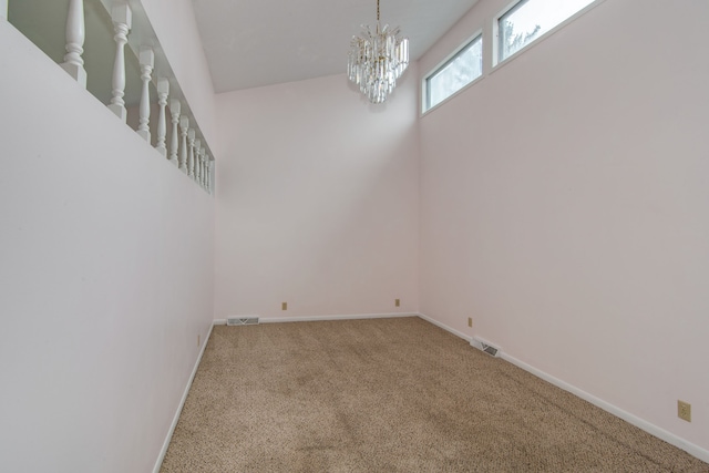 empty room with carpet floors and a chandelier