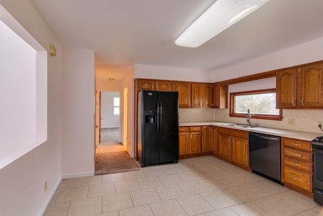 kitchen with decorative backsplash, sink, light tile patterned floors, and black appliances