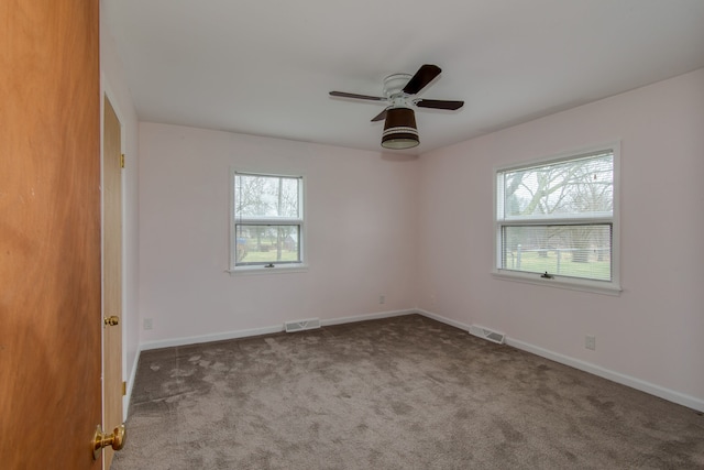 carpeted empty room with ceiling fan and a healthy amount of sunlight