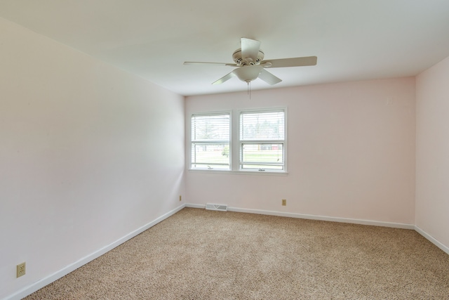 carpeted spare room with ceiling fan