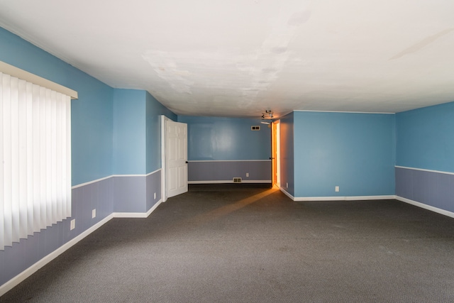 unfurnished room with dark carpet