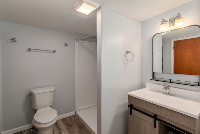 bathroom with a shower, vanity, wood-type flooring, and toilet