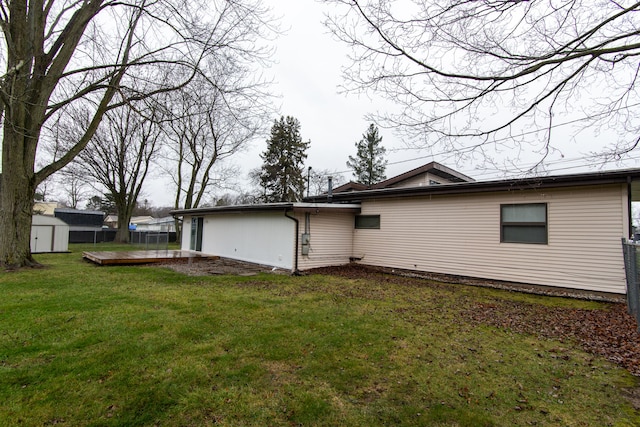 view of home's exterior with a lawn, a storage unit, and a deck