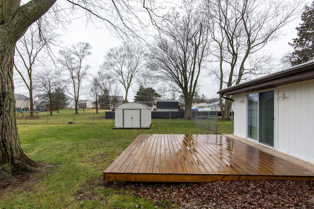 wooden deck with a lawn and a storage unit