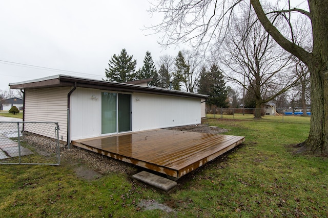 back of house featuring a lawn and a wooden deck