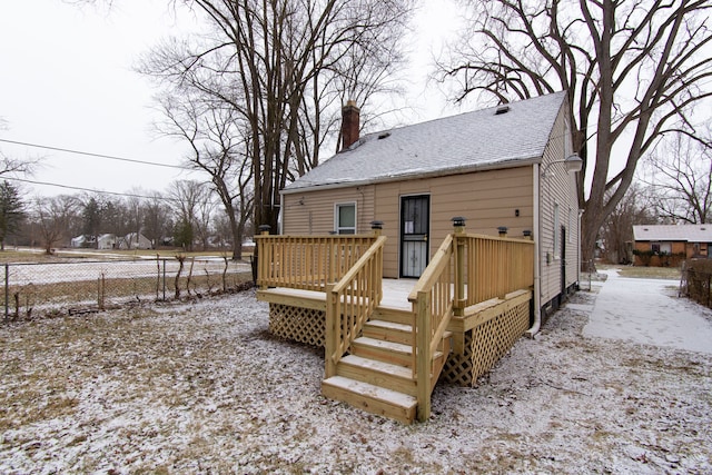 snow covered house featuring a wooden deck