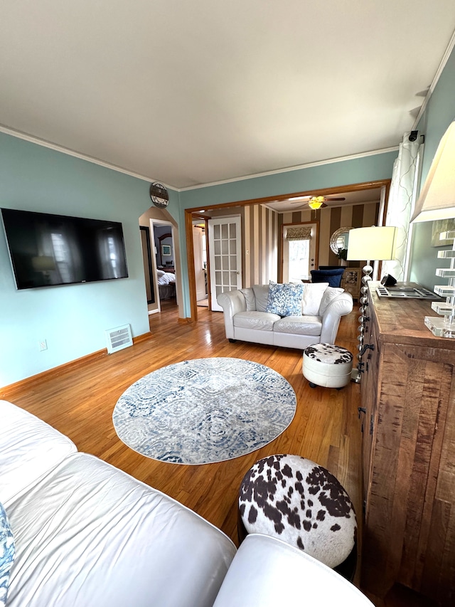 living room with ceiling fan, hardwood / wood-style floors, and ornamental molding