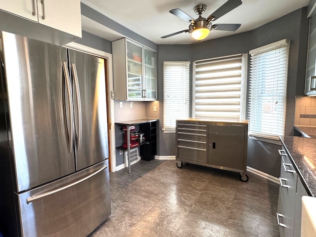 kitchen with backsplash, stainless steel refrigerator, and ceiling fan