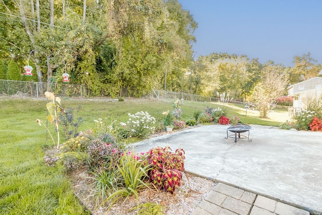 view of home's community featuring a lawn, a patio area, and an outdoor fire pit