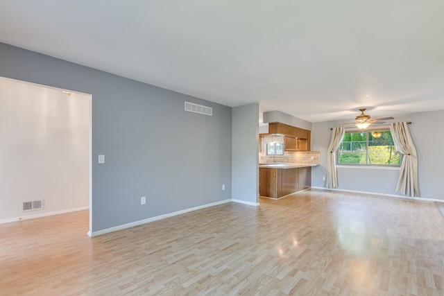 unfurnished living room with ceiling fan and light hardwood / wood-style flooring