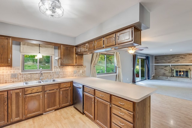 kitchen with kitchen peninsula, ceiling fan, sink, decorative light fixtures, and dishwasher