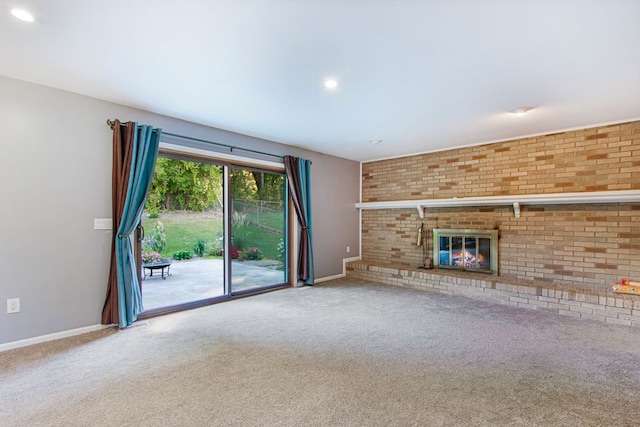 unfurnished living room with carpet, brick wall, and a brick fireplace