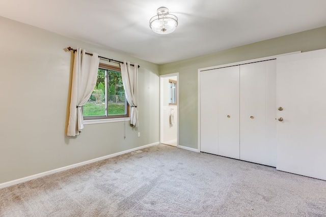 unfurnished bedroom with light carpet and a closet