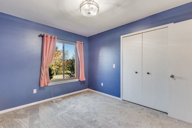 unfurnished bedroom featuring light colored carpet and a closet