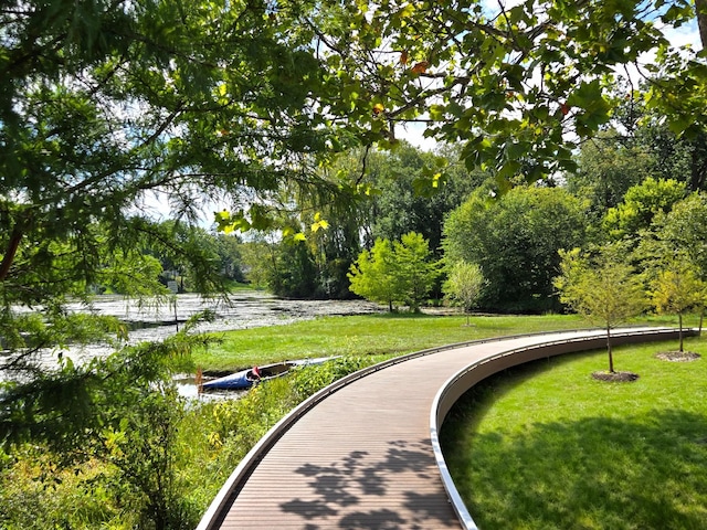 surrounding community featuring a lawn and a water view