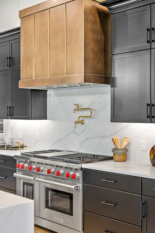 kitchen featuring double oven range and backsplash