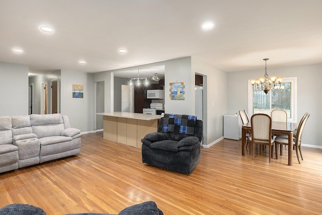 living room featuring light hardwood / wood-style floors and a notable chandelier