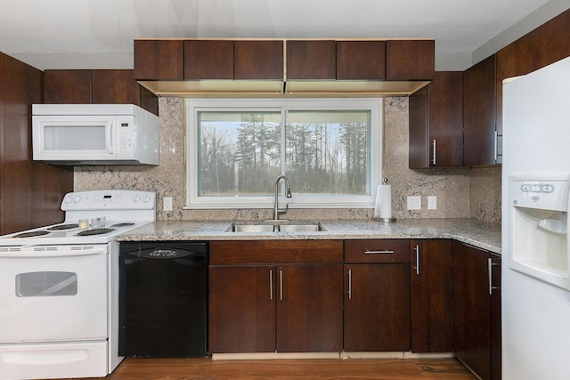 kitchen with sink, tasteful backsplash, light stone counters, white appliances, and dark brown cabinets