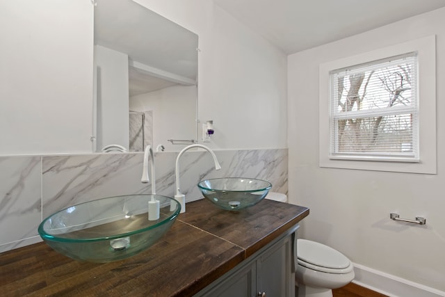 bathroom with hardwood / wood-style floors, vanity, toilet, and backsplash