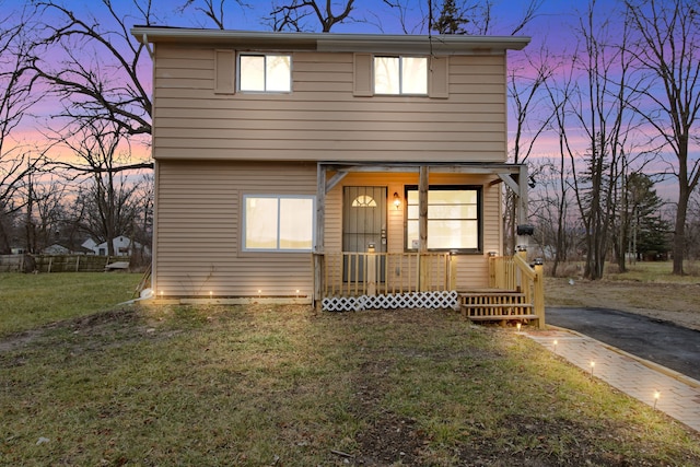 view of front property featuring a lawn and a porch