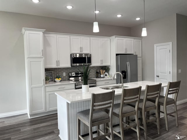 8289 Grande Lake Cir, Temperance, MI 48182 - kitchen with appliances with stainless steel finishes, an island with sink, dark wood-type flooring, tasteful backsplash, and white cabinets