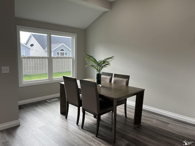 dining room with plenty of natural light, lofted ceiling with beams, and dark hardwood / wood-style floors