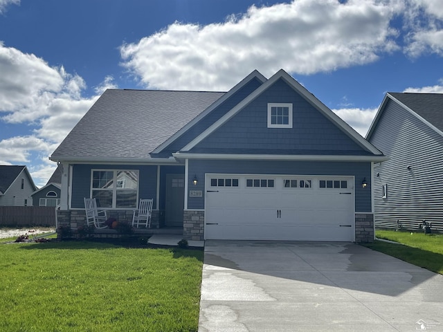 craftsman inspired home with a porch, a garage, and a front lawn