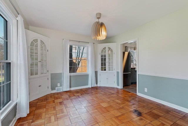 unfurnished dining area featuring parquet floors