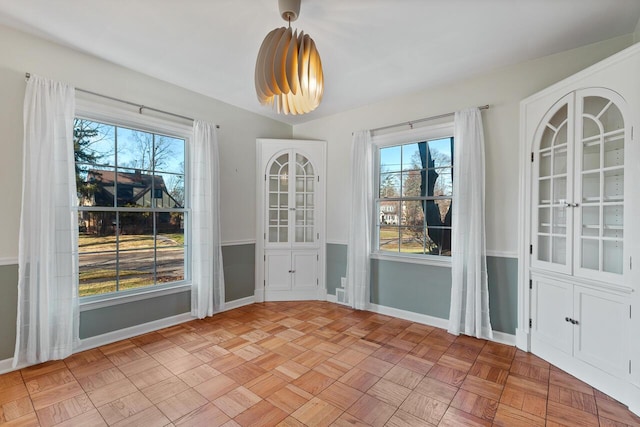 unfurnished dining area featuring light parquet flooring and a healthy amount of sunlight