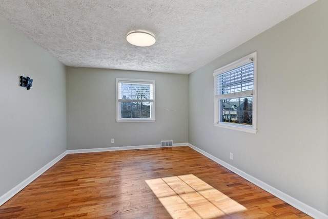 empty room featuring hardwood / wood-style flooring and a textured ceiling