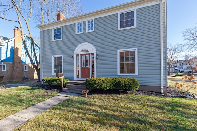 colonial-style house featuring a front yard