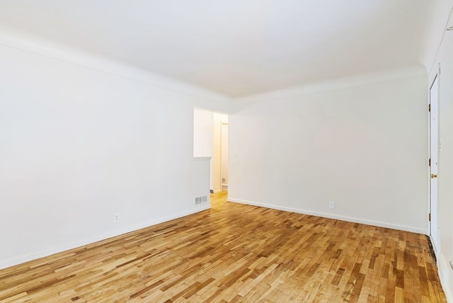 spare room featuring hardwood / wood-style floors and ornamental molding