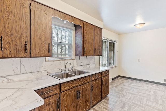 kitchen with light parquet flooring, tasteful backsplash, and sink