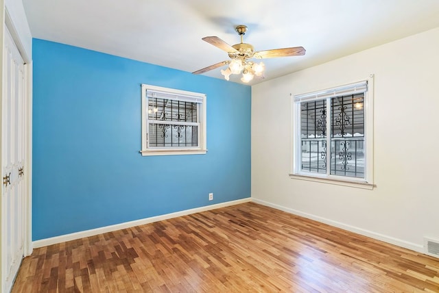 empty room with hardwood / wood-style flooring and ceiling fan