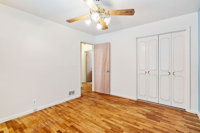 unfurnished bedroom with ceiling fan, light hardwood / wood-style floors, and a closet